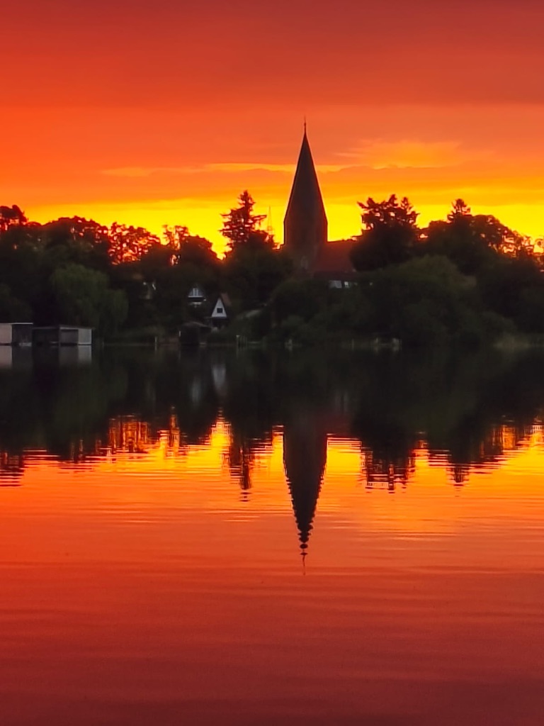 Kirche von Damerow im roten Sonnenuntergang gespiegelt im Jabelschen See