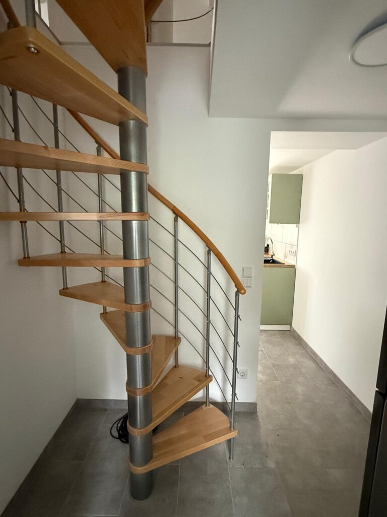 Wendeltreppe zwischen den beiden Ebenen der Maisonette-Ferienwohnung in Damerow