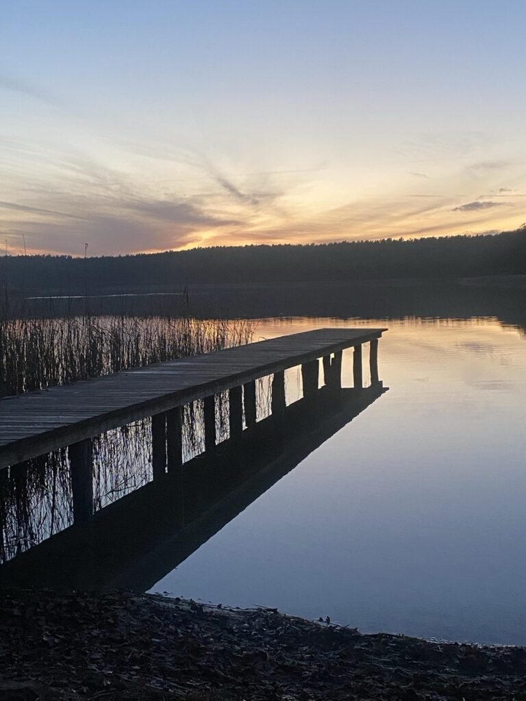 Holzsteg am Jabelschen See im Sonnenuntergang mit Spiegelung