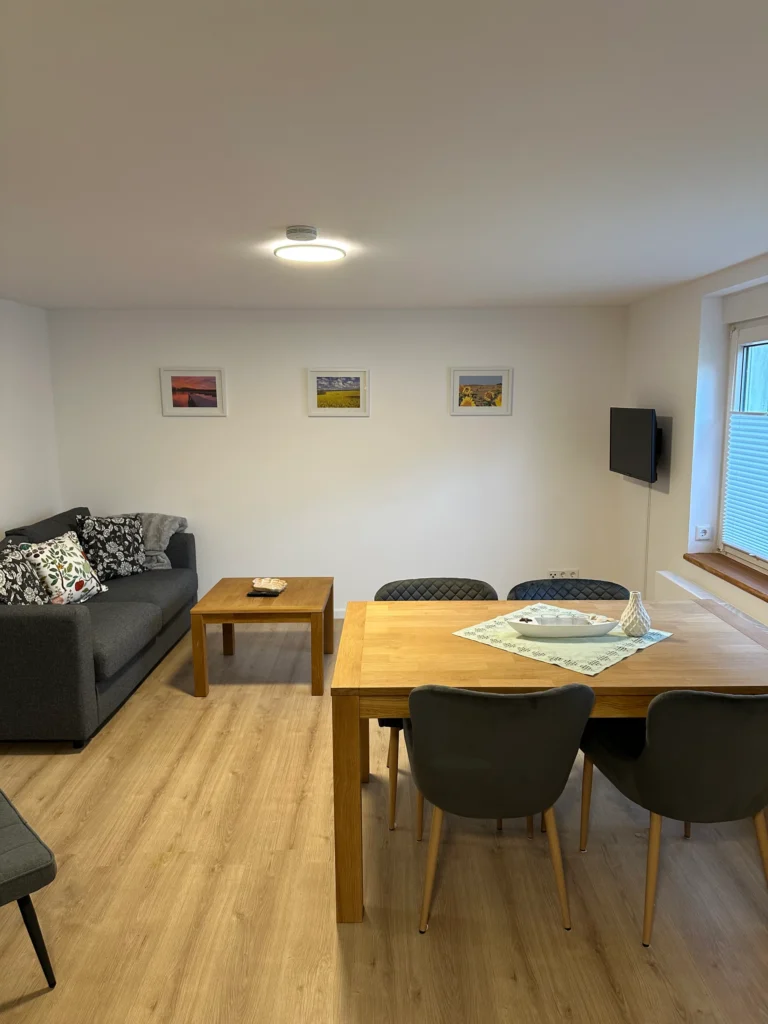 Wohnbereich der Ferienwohnung mit Sofa und Esstisch